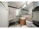 Modern bathroom features a glass shower, black hexagon floor, sleek vanity, and matte gold hardware at 1243 Monroe St, Denver, CO 80206