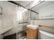Modern bathroom features a glass shower, black hexagon floor, sleek vanity, and matte gold hardware at 1243 Monroe St, Denver, CO 80206