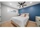 Stylish bedroom with accent wall, hardwood floors, modern ceiling fan, and natural light at 1243 Monroe St, Denver, CO 80206