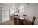 Dining area with a round glass table and stylish seating adjacent to the modern kitchen at 1243 Monroe St, Denver, CO 80206