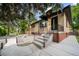 Classic home with brick accents, concrete steps and covered porch in a mature treed setting at 1243 Monroe St, Denver, CO 80206