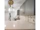 Close up of the kitchen featuring gray cabinets, quartz countertops, and modern pendant lighting at 1243 Monroe St, Denver, CO 80206