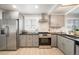 Beautiful kitchen featuring stainless steel appliances, gas range, gray cabinets, and hardwood floors at 1243 Monroe St, Denver, CO 80206