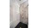 This luxury shower features gray tiled walls, a bench, black hexagon floors, and gold shower hardware at 1243 Monroe St, Denver, CO 80206