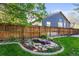 Landscaped backyard featuring a charming pond with stone accents and a wooden fence at 9162 W Unser Ave, Littleton, CO 80128