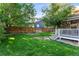 Well-manicured backyard with mature trees, lush lawn, and a charming patio at 9162 W Unser Ave, Littleton, CO 80128