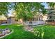 Lush backyard with a well-maintained lawn, mature trees, and a deck for outdoor enjoyment at 9162 W Unser Ave, Littleton, CO 80128