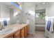 Bathroom with double sink vanity, tile floors, large mirror, and a view from the window at 9162 W Unser Ave, Littleton, CO 80128