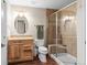 Updated bathroom with wooden vanity, tiled shower with glass door, and modern fixtures at 9162 W Unser Ave, Littleton, CO 80128