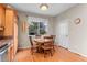 Bright dining area with wooden floors, table, chairs, a view to the backyard, and plenty of natural light at 9162 W Unser Ave, Littleton, CO 80128