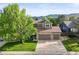 Charming home with a stone facade, two-car garage, and large tree in the front yard at 9162 W Unser Ave, Littleton, CO 80128