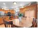Charming kitchen featuring wooden cabinets, granite countertops, stainless steel appliances, and breakfast table at 9162 W Unser Ave, Littleton, CO 80128