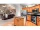 Modern kitchen with stainless steel appliances, wooden cabinets, and an adjacent living space at 9162 W Unser Ave, Littleton, CO 80128