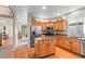Well-lit kitchen with stainless steel appliances, wood cabinets, and hardwood floors at 9162 W Unser Ave, Littleton, CO 80128