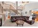 Open-concept living room with high ceilings, staircase, fireplace, leather sofa, and access to the kitchen at 9162 W Unser Ave, Littleton, CO 80128