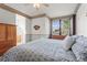 Comfortable main bedroom featuring a ceiling fan, large window, and en suite bathroom at 9162 W Unser Ave, Littleton, CO 80128