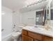 Bright bathroom featuring a tiled shower/tub combo, and large mirror with vanity at 11905 E Harvard Ave # 208, Aurora, CO 80014
