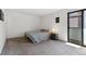 Clean bedroom with sliding glass door, neutral carpet and minimalist decor at 11905 E Harvard Ave # 208, Aurora, CO 80014