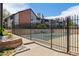 Community pool area enclosed by a black iron fence and brick retaining wall at 11905 E Harvard Ave # 208, Aurora, CO 80014