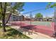 Community tennis court surrounded by mature trees and well-maintained landscaping at 11905 E Harvard Ave # 208, Aurora, CO 80014