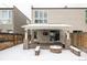 Covered patio with fire pit and seating area in winter at 1576 W Maple Ave, Denver, CO 80223