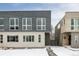 Modern two-unit building with gray and wood siding, snowy landscape at 1576 W Maple Ave, Denver, CO 80223