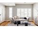 Light and airy living room with gray sofa and white plantation shutters at 1576 W Maple Ave, Denver, CO 80223