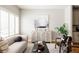 Bright living room with light gray sofa, white shutters, and modern decor at 1576 W Maple Ave, Denver, CO 80223