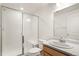 Bright bathroom featuring a glass enclosed shower and a light wood vanity with a marble countertop at 11124 Xanadu St, Commerce City, CO 80022