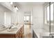 Bright bathroom offers dual vanity, tub, and natural light at 11124 Xanadu St, Commerce City, CO 80022