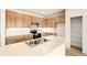 Well-lit kitchen showcasing natural wood cabinets, stainless steel appliances, and a marble-top island at 11124 Xanadu St, Commerce City, CO 80022