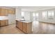 Open-concept kitchen with an island, wood cabinets, and views of the outdoor space through large windows at 11124 Xanadu St, Commerce City, CO 80022