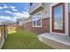 Home backyard view featuring new artificial turf and a brick wall at 14176 Jackson St, Thornton, CO 80602
