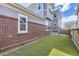 View of the home's backyard with artificial turf and brick accent at 14176 Jackson St, Thornton, CO 80602
