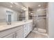 A stylish bathroom with a double vanity, large mirror and glass shower with a bench at 14176 Jackson St, Thornton, CO 80602