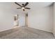 A spacious bedroom with neutral walls, carpet, a ceiling fan and a view into the bathroom at 14176 Jackson St, Thornton, CO 80602
