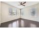 Bright bedroom with gleaming hardwood floors and three large windows offering plenty of natural light at 14176 Jackson St, Thornton, CO 80602