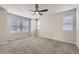 A bedroom with neutral colored walls, carpet, ceiling fan, and a large window at 14176 Jackson St, Thornton, CO 80602