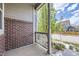 Cozy front porch featuring brick accents and a view of the quiet street and nearby home at 14176 Jackson St, Thornton, CO 80602