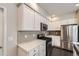 Stylish kitchen featuring stainless steel appliances, white cabinetry, and light countertops at 14176 Jackson St, Thornton, CO 80602