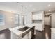 Bright kitchen with stainless steel sink, white cabinets, dark floors and view to dining area at 14176 Jackson St, Thornton, CO 80602
