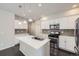 Modern kitchen features white cabinets, stainless steel appliances, and a center island with sink and pendant lighting at 14176 Jackson St, Thornton, CO 80602