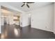 Open-concept living room with dark hardwood floors that transitions into the adjacent dining area and kitchen at 14176 Jackson St, Thornton, CO 80602