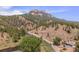 Picturesque aerial shot of a home surrounded by rolling hills and a tranquil river setting at 2230 S Platte River Rd, Sedalia, CO 80135