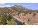 Scenic aerial view of a winding mountain road, river, and densely forested hillside at 2230 S Platte River Rd, Sedalia, CO 80135
