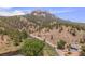 Picturesque aerial view of a house by a river, surrounded by lush green trees and hills at 2230 S Platte River Rd, Sedalia, CO 80135