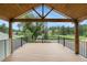 Covered deck with wood floors offering beautiful views of the surrounding greenery at 2230 S Platte River Rd, Sedalia, CO 80135