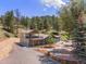 Two-story home with a deck and patio areas surrounded by lush trees and natural landscape at 2230 S Platte River Rd, Sedalia, CO 80135