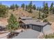 Charming home with a two-car garage, inviting porch, and attractive landscaping, nestled in a serene natural setting at 2230 S Platte River Rd, Sedalia, CO 80135