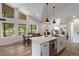 Modern kitchen with white cabinetry, stainless steel appliances, and an island with pendant lighting at 2230 S Platte River Rd, Sedalia, CO 80135